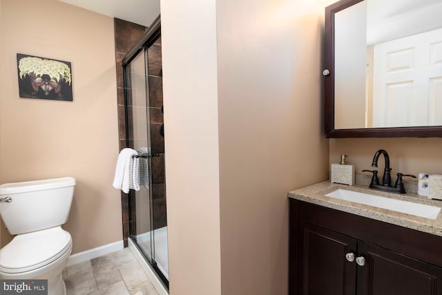 full bathroom featuring vanity, toilet, baseboards, and a stall shower