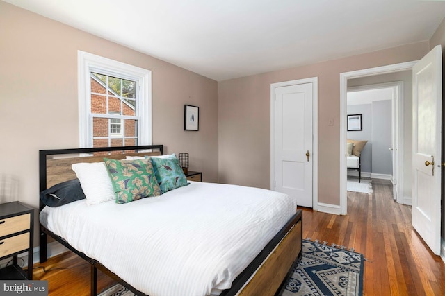 bedroom with baseboards and hardwood / wood-style flooring
