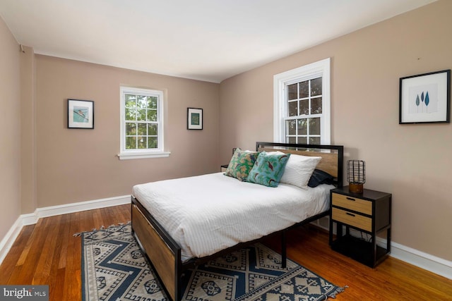 bedroom featuring baseboards and wood finished floors