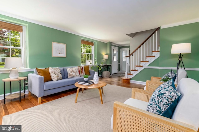 living room featuring ornamental molding, wood finished floors, and stairway
