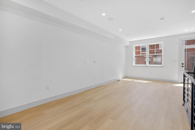 unfurnished living room with recessed lighting, baseboards, and light wood-type flooring