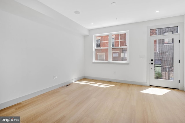 empty room featuring baseboards, recessed lighting, wood finished floors, and visible vents