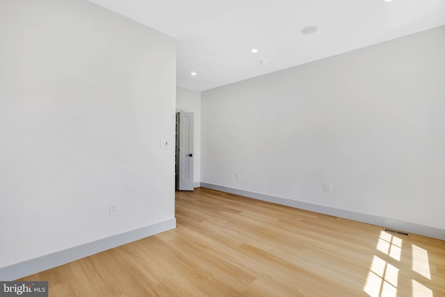 empty room with recessed lighting, baseboards, visible vents, and light wood-type flooring