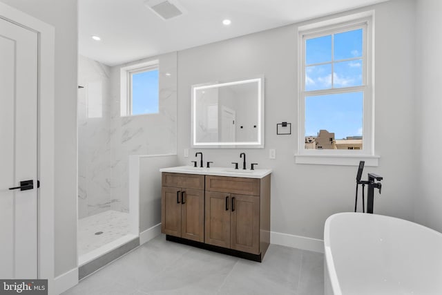 bathroom featuring double vanity, a freestanding tub, baseboards, a sink, and a marble finish shower