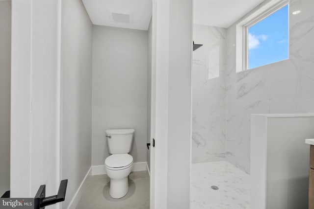 full bath featuring a marble finish shower, baseboards, vanity, and toilet