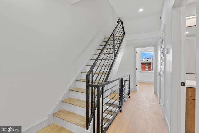 staircase with recessed lighting, baseboards, and wood finished floors