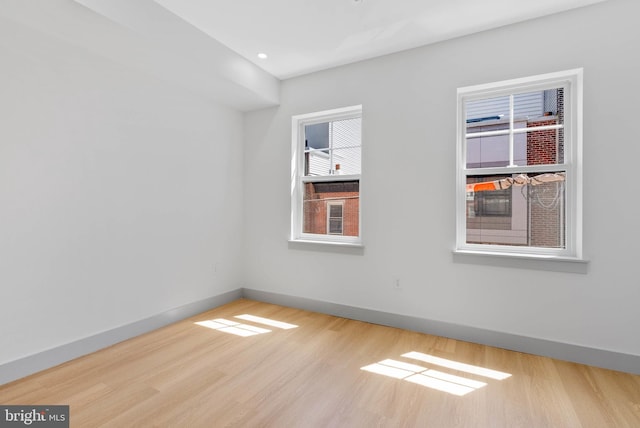 unfurnished room with baseboards and wood finished floors