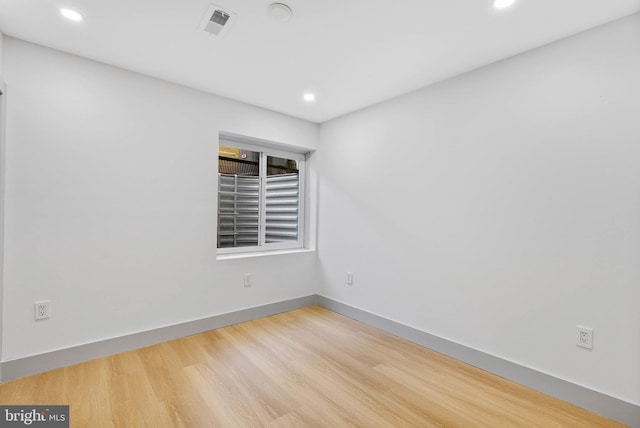 empty room featuring recessed lighting, baseboards, visible vents, and wood finished floors