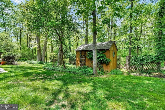 view of yard with an outbuilding, a storage shed, and fence