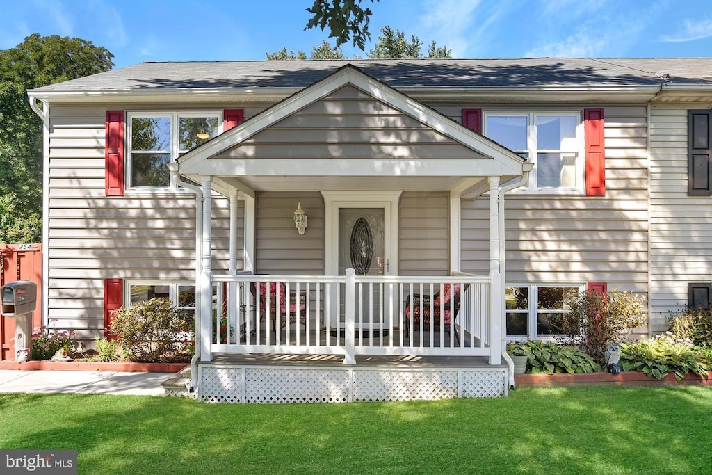 view of front of property featuring covered porch and a front yard