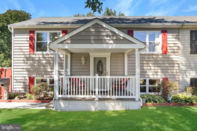 view of front of property featuring covered porch and a front yard