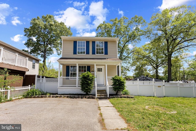 view of front facade with fence, covered porch, and a front yard