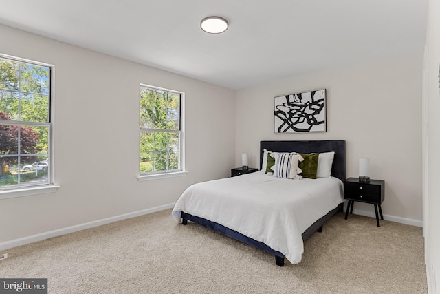 carpeted bedroom with baseboards and multiple windows
