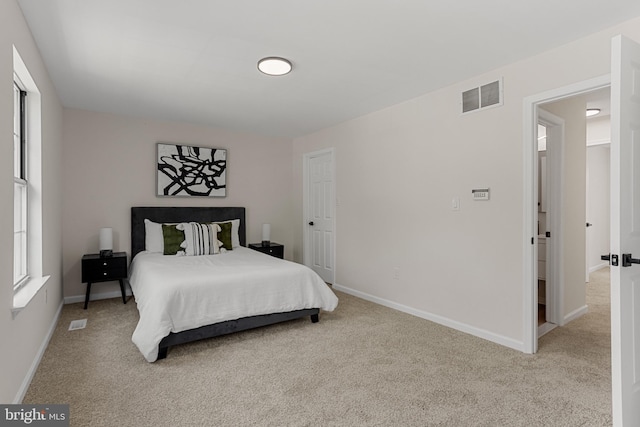 bedroom featuring baseboards, visible vents, and light carpet