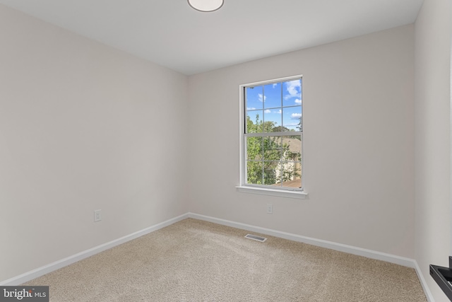 carpeted spare room with baseboards and visible vents