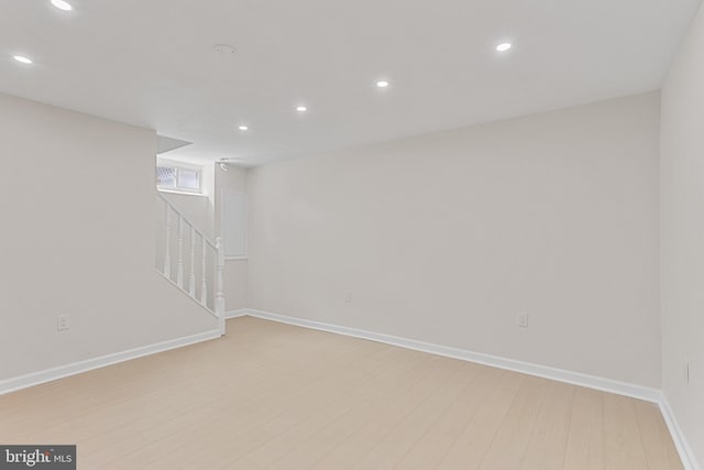 basement with recessed lighting, baseboards, stairway, and light wood-type flooring