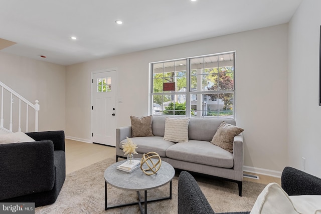 living area with visible vents, stairs, wood finished floors, baseboards, and recessed lighting