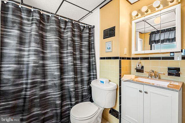 1223 Fitzgerald St, Philadelphia, PA 19148 - bathroom with toilet, vanity, wainscoting, a paneled ceiling, and tile walls