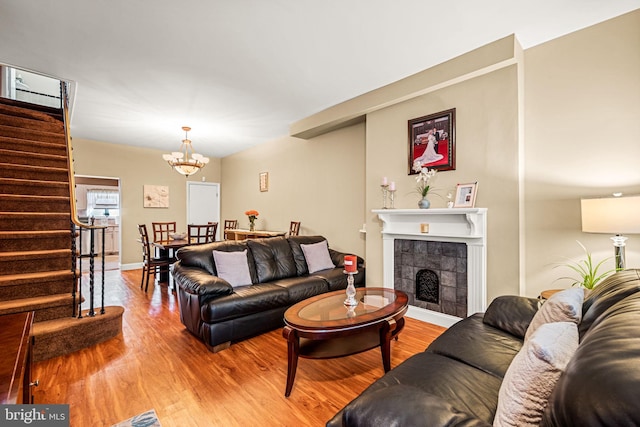 1223 Fitzgerald St, Philadelphia, PA 19148 - living area with stairs, wood finished floors, a chandelier, a tile fireplace, and baseboards