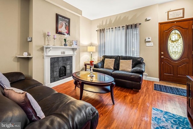 1223 Fitzgerald St, Philadelphia, PA 19148 - living room featuring wood finished floors, a tiled fireplace, and baseboards