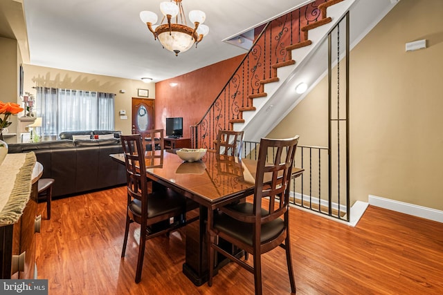 1223 Fitzgerald St, Philadelphia, PA 19148 - dining area with wood finished floors, a chandelier, baseboards, and stairs