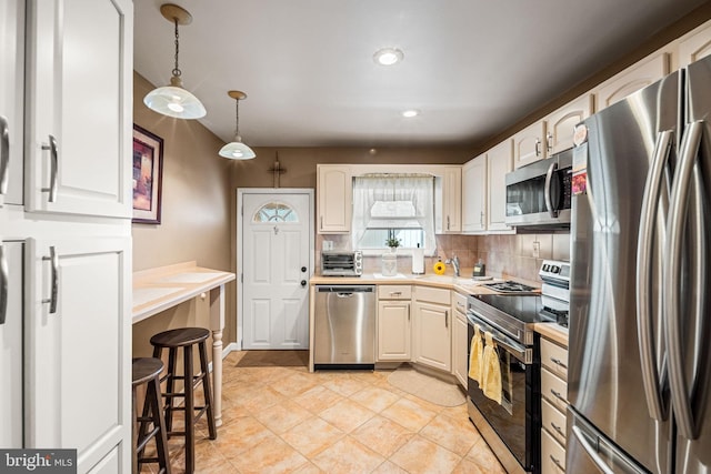 1223 Fitzgerald St, Philadelphia, PA 19148 - kitchen with stainless steel appliances, light countertops, decorative backsplash, decorative light fixtures, and light tile patterned floors
