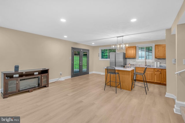 7509 Glade Dr, Fort Washington, MD 20744 - kitchen featuring freestanding refrigerator, a breakfast bar, light wood-style flooring, baseboards, and light countertops