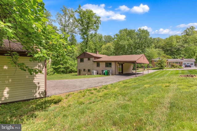 7509 Glade Dr, Fort Washington, MD 20744 - back of property with asphalt driveway, a yard, and central AC