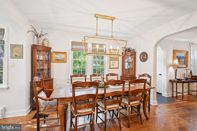 835 Beechwood Rd, Havertown, PA 19083 - dining area with arched walkways, wood finished floors, a chandelier, and baseboards