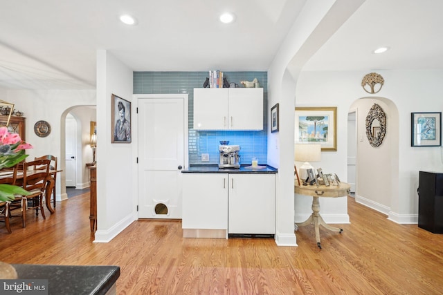835 Beechwood Rd, Havertown, PA 19083 - kitchen with arched walkways, light wood finished floors, dark countertops, baseboards, and recessed lighting