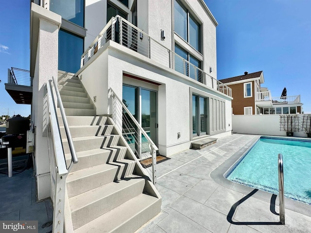 exterior space featuring a patio area, fence, and stairway