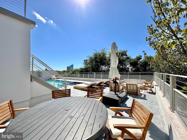 wooden terrace featuring an outdoor living space, outdoor dining area, fence, a fenced in pool, and a patio