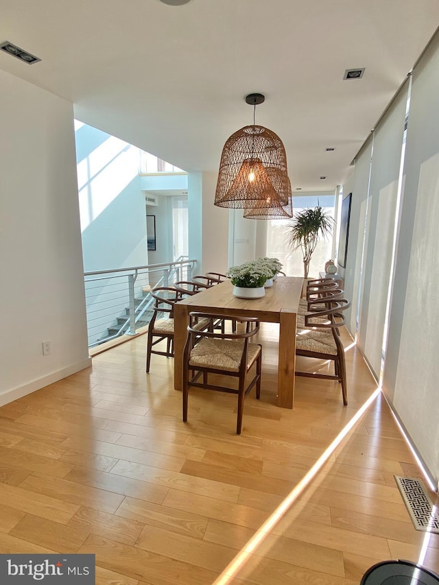 dining space with light wood-type flooring and visible vents