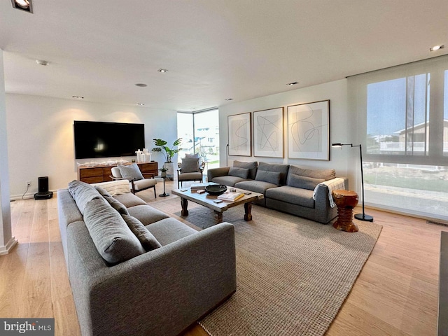 living room with recessed lighting, baseboards, visible vents, and light wood-style floors