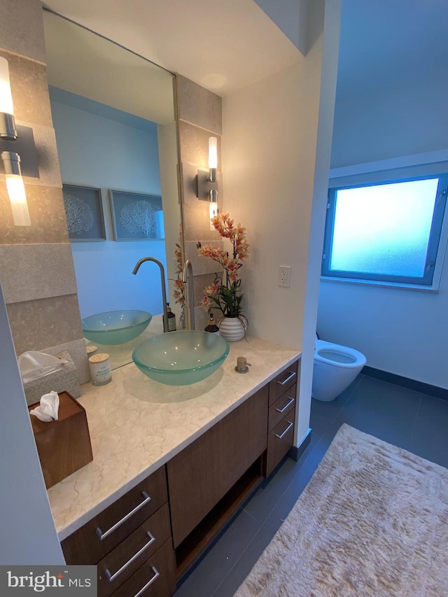 bathroom featuring toilet, tile patterned flooring, and vanity