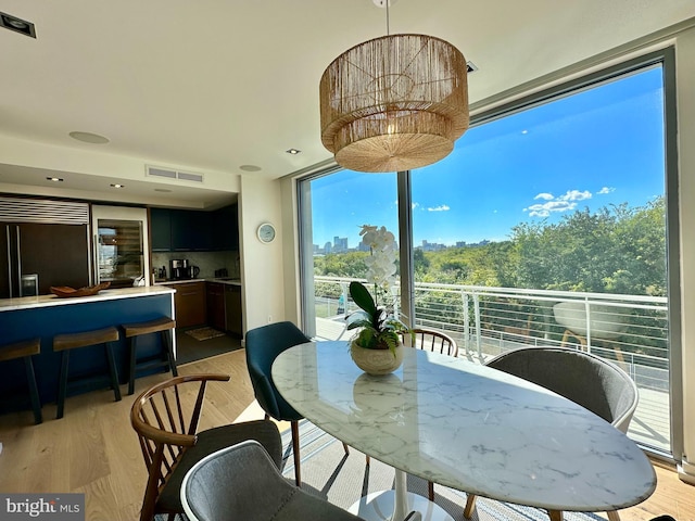 dining space with light wood-type flooring and visible vents