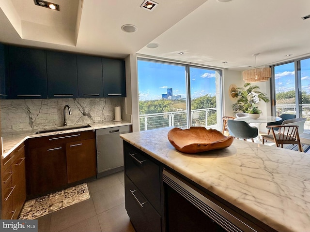 kitchen with a sink, dishwasher, light tile patterned floors, tasteful backsplash, and floor to ceiling windows