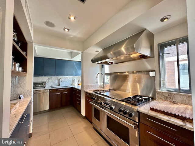 kitchen featuring a sink, wall chimney exhaust hood, appliances with stainless steel finishes, and tasteful backsplash