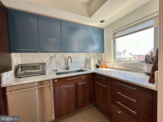 kitchen with stainless steel dishwasher, decorative backsplash, a toaster, light stone counters, and a sink