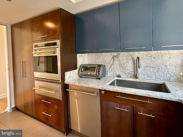 kitchen with backsplash, a sink, appliances with stainless steel finishes, and a toaster