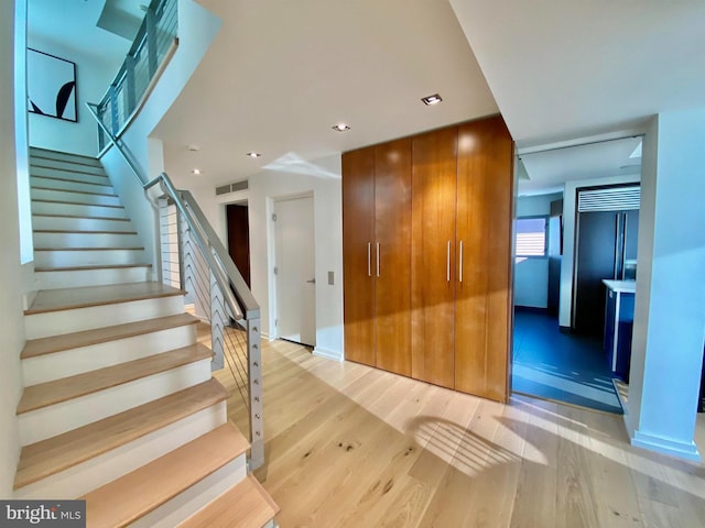 stairway with recessed lighting, baseboards, visible vents, and wood finished floors