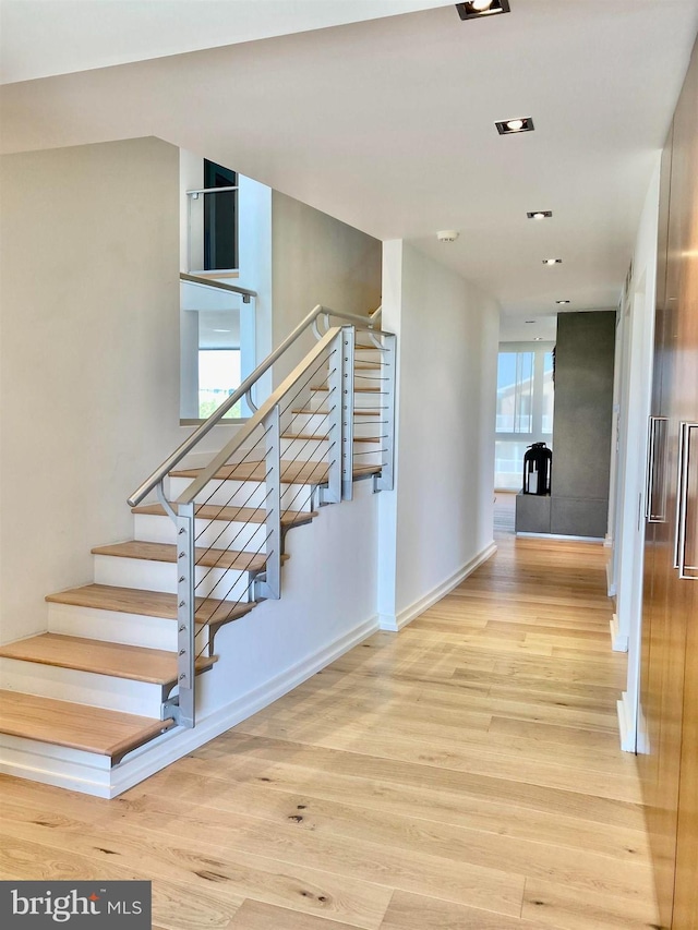 staircase with baseboards and wood finished floors