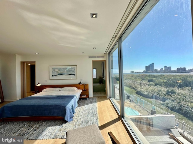bedroom featuring baseboards, a city view, and wood finished floors