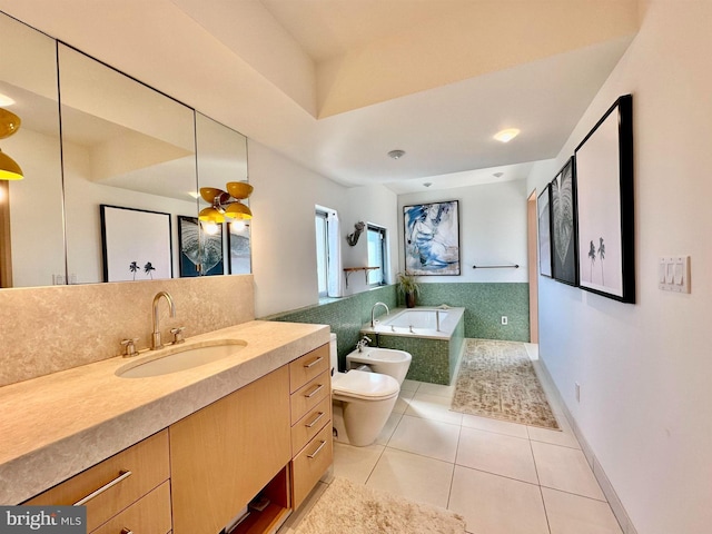 bathroom with tile patterned flooring, a garden tub, vanity, toilet, and a bidet