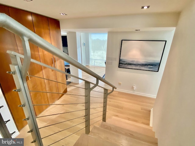 stairs with baseboards, recessed lighting, and wood finished floors