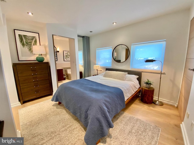 bedroom with baseboards, recessed lighting, ensuite bathroom, and wood finished floors
