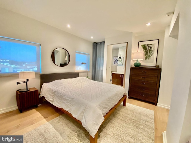 bedroom featuring baseboards, connected bathroom, light wood-style flooring, and recessed lighting