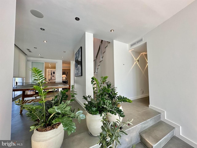 stairway featuring recessed lighting, baseboards, visible vents, and concrete floors