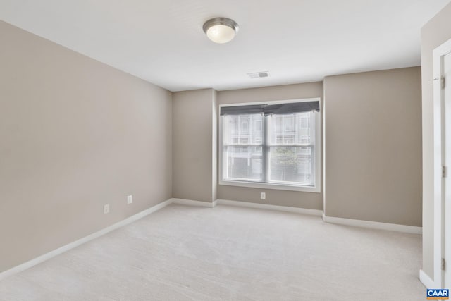 unfurnished room with baseboards, carpet flooring, and visible vents