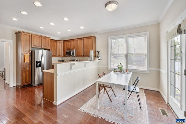 kitchen with visible vents, crown molding, a peninsula, recessed lighting, and stainless steel appliances